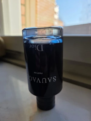 Dior Sauvage Parfum 100ml - Dior Sauvage Parfum är en exklusiv herrdoft i en elegant mörkblå glasflaska med silverdetaljer. Flaskan rymmer 100 ml och har en stilren, modern design. Doften är intensiv och maskulin, perfekt för dig som vill sticka ut med en lyxig parfym.