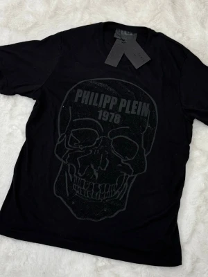 Svart t-shirt från Philipp Plein - svart t-shirt från Philipp Plein med diskret tryck framtill och logga i nacken. 