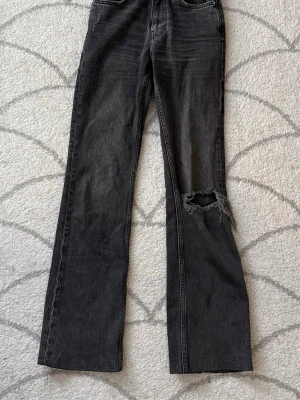 Gråa jeans - Gråa jeans från Gina som jag älskar men tyvärr har blivit för små nu. Dom har rak passform och hål på ena knäet. Dom är upplimmade med tyglim ca 5 cm i benen för att passa mig som är 158 cm, men det ska inte vara något problem att dra tillbaka dom, inget typ är avklippt.