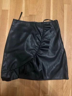 Svart kjol med volang skin  - Snygg svart kjol i skin med volang ge gärna ett prisförslag 🫶🏻