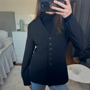 Svart kavaj med knappar - Åtsittande kavaj i midjan, för stor på mig. Använd någon gång men är som ny, är väldigt bra skick.