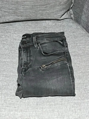 Replay svarta skinny jeans med dragkedjor - Säljer ett par svarta skinny jeans från Replay med coola dragkedjedetaljer framtill. Jeansen har fem fickor, soprena sömmar och en tight passform som sitter sny favorite. Perfekta topping till streetwear eller en edgy look uniform.