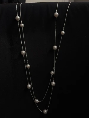 Silverfärgat halsband med pärlor - Snyggt långt halsband med dubbla tunna silverfärgade kedjor och vita pärlor i olika storlekar. Perfekt för att ge en elegant touch till din outfit. Kedjan är tunn och smidig, och pärlorna är jämnt utspridda längs hela halsbandet. Användes bara 3 gånger, köpt här på plik💕