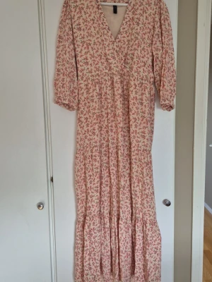 Blommig långklänning från Y.A.S - Långklänning från Y.A.S med ljus botten och små blommor i rosa och lila. Klänningen har v-ringning, trekvartsärm och volangdetaljer. Perfekt för sommarens alla tillfällen och har en luftig passform. 🌸🌸 Länk till den https://www.shere.nl/en/yas-dress-yascesara-jurk.html