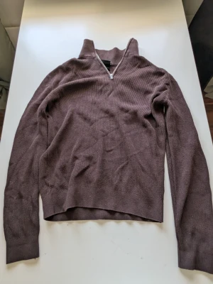 Brun Quarterzip - Mysig brun ribbstickad tröja med halv dragkedja och hög krage. Inga fel märks på den.