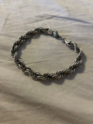 Snyggt tvinnat silverarmband äkta silver 925 - Stilrent armband i silverfärgat metall med tvinnad kedjedesign och karbinlås. Perfekt accessoar för att lyfta din outfit med en cool och tidlös känsla. Passar dig som gillar klassiska smycken med lite extra edge.