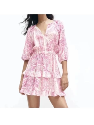 Rosa och vit klänning från Zara - Supersöt kortklänning i rosa och vitt med blommigt mönster och volangdetaljer. Klänningen har v-ringning, trekvartsärm och resår i midjan! 