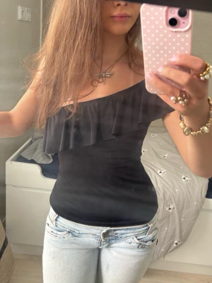 One shoulder svart volangtopp  - Så fin svart one shoulder volangtopp. Jag är 168 och det är mina bilder, köp via köp nu direkt eller Swish, kvar tills markerad som såld 💖 
