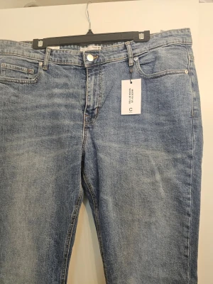 Blå raka jeans från Cubus - Snygga blå jeans från Cubus med klassisk femficksmodell och raka ben. Jeansen har en ljus tvätt och är tillverkade i bomull med en liten mängd stretch för extra komfort. Perfekta för en avslappnad och trendig look.