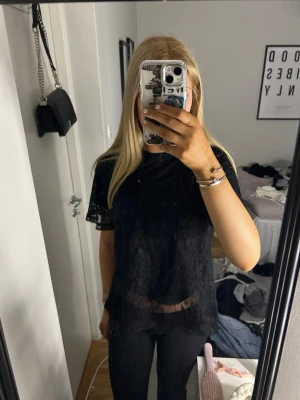 Svart spetsblus med kort ärm - använd en gång, storlek står inte men ungefär M. Genomskinlig, har tröja under på första bilden