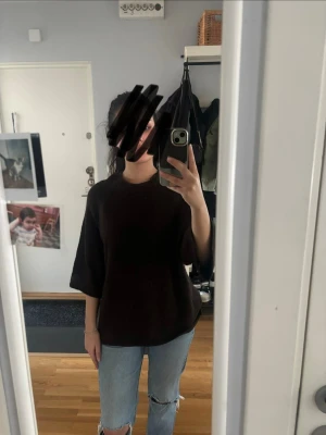 Svart loose t-shirt med trekvartsärm - En svart t-shirt med loose passform och trekvartsärm. Enkel och stilren design som passar till det mesta. Perfekt för dig som gillar en avslappnad och trendig look.
