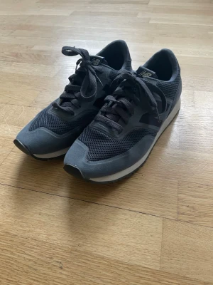 Grå New Balance 520 sneakers - Snygga grå sneakers från New Balance, modell 620. Skorna har en snygg och klassisk ovandel, med klassisk snörning och låg profil. Perfekta för en sportig och stilren look. Diskret logga på sidan och bekväm sula för vardagsbruk.