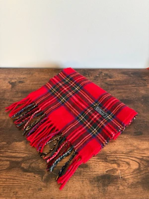 Burberry Halsduk - Vintage Burberrys halsduk i 100% lambswool. Made in England. Klassisk check i mörkare/bruna toner med diskret och tidlös look. Väldigt bra skick med endast mindre tecken på användning. Perfekt för en clean casual/old money stil.