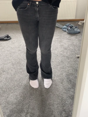 Svarta bootcut jeans med hög midja - Snygga svarta bootcut jeans med låg midja och klassiska fem fickor. Jeansen har en lätt tvättad look och är tillverkade i stretchigt denim för skön passform. Perfekta till en avslappnad stil och passar till det mesta i garderoben.