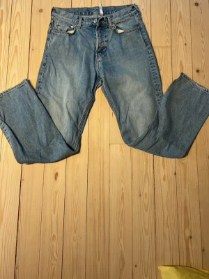 Blå weekday raka jeans - Klassiska blå weekday jeans med rak passform och knappgylf. Jeansen har fem fickor och är tillverkade i slitstark denim. Perfekta för en avslappnad och tidlös stil.