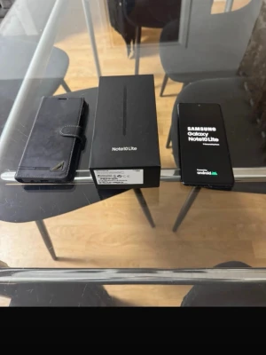 Samsung Galaxy Note10 Lite svart - Samsung Galaxy Note10 Lite i svart med stor skärm och stilren design. Kommer med originalkartong och ett svart fodral i läderimitation med plats för kort. Android-telefon med S Pen-stöd och modern look.