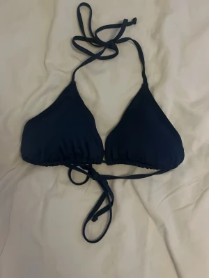 Mörkblå trekantsbikini med knyt - Snygg mörkblå trekantsbikini med knyt både i nacken och runt ryggen. Från lager 157 i storlek L   !! TVÄTTAS INNAN !!