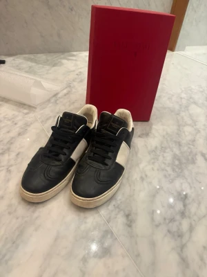 Svarta och vita Valentino sneakers - Säljer mina Valentino flycrews pga att de är för små! De är i storlek 40 men passar 41. 4 nitar fattas men går lätt att köpa😃box och allt det finns!