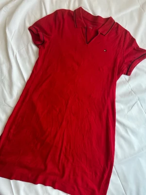 Röd pikéklänning från Tommy Hilfiger - Red Tommy Hilfiger polo dress with embroidered logo detail and black contrast trim. Simple and timeless preppy/Y2K style ✨  Size: L Condition: Good condition Color: Red with black details  Perfect everyday dress with a sporty vintage feel.  