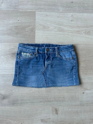 Blå Y2K Mini Skirt Soundgirl Jeanskjol Embroidery - Mycket fin kjol i blå färg. Kjolen är i mycket bra skick och sparsamt använda. |  Äkta som allt annat jag säljer! ✅ |  Storlek: XS / 34  | Skick: Mycket Bra Skick  | Färg: Blå | Märke: Soundgirl | Modell: Kjol |   Hör gärna av dig vid frågor så svarar jag så fort jag kan! 😁 |