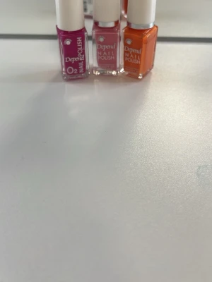 Depend nagellack i lila ljusrosa & orange - Tre snygga nagellack från Depend i färgerna lila , ljusrosa och orange. Flaskorna är små och smidiga med vita korkar. Perfekt för dig som vill variera din nagellook med trendiga och färgstarka nyanser.