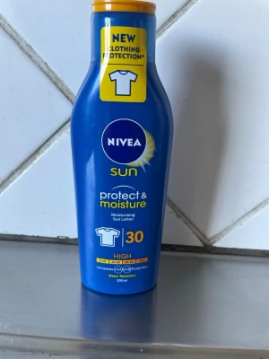Nivea Sun Protect & Moisture SPF 30 - Nivea Sun Protect & Moisture SPF 30 solkräm i blå plastflaska med gul kork. Återfuktande solskyddslotion som ger högt skydd mot UVA/UVB och är vattenresistent. Innehåller 200 ml och har extra skydd för kläder mot fläckar.