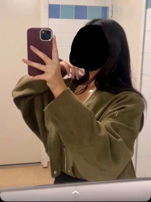 Olivgrön croppad jacka i mocka-look Från Zara - Snygg olivgrön croppad jacka med vida ärmar och dragkedja framtill. Jackan har en modern oversized passform och är tillverkad i ett material som liknar mocka.  Jackan är från Zara! Denna är använd typ 2 gånger då!