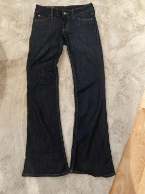 Weekday jeans - Säljer ett par mörkblå bootcut jeans med kontrastsömmar. Jeansen är lågmidjade och från weekday cheap monday!