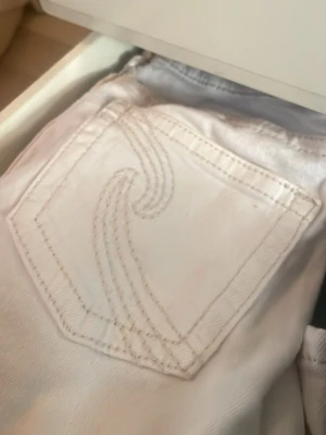 Vita flare jeans från Gina Tricot - Säljer ett par vita Y dixie low flare jeans från Gina Tricot. Jeansen har snygga bakfickor med dekorativa sömmar och är tillverkade i bomull. Perfekta för dig som gillar trendiga och bekväma jeans med utsvängda ben.