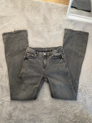 Low flare jeans - Säljer ett par snygga gråa jeans i storlek 27, i modellen ”low flare”, går att justera dem i midjan. Från Grunt, köpta på Kidsbrandstore, nypris 649kr Fint skick!!