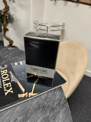 Good Girl parfym från Carolina Herrera - Good Girl parfym från Carolina Herrera i elegant svart och guld förpackning. Flaskan har en lyxig och modern design som verkligen sticker ut. Perfekt för dig som gillar exklusiva dofter och snygga detaljer på parfymhyllan.