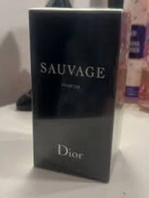 Dior Sauvage Eau de Parfum - Dior Sauvage Eau de Parfum är en ikonisk herrdoft i en elegant mörkblå glasflaska med silverdetaljer. Flaskan har en stilren, rund form och kommer i en svart kartong med vit text. En modern och fräsch parfym som utstrålar lyx.