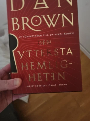 Två spännande romaner: Brown & Griffiths - Säljer två skönlitterära böcker: 'Den yttersta hemligheten' av Dan Brown med röd och guld omslag samt 'Dödlig tid' av Elly Griffiths med ett omslag som visar en park och London Eye i skymning. Perfekt för dig som gillar mysterier och thrillers. 