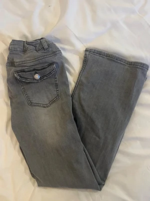 Gråa lågmidjade bootcut jeans  - Säljer dessa grå Lågmidjade bootcut jeansen från Kappahl i storlek 158 🤍 jag är 155 cm lång och brukar bära xs/s i byxor och de funkar för mig! 