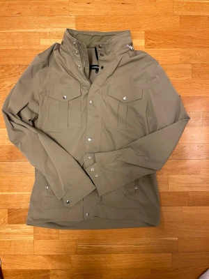 J Lindeberg field jacket - Säljer en snygg field jacket från j.lindeberg i modellen bailey. Storleken är L men passar mig bra som brukar ha M. Färgen heter aloe green men är olivgrön. Skriv gärna ifall ni undrar något!