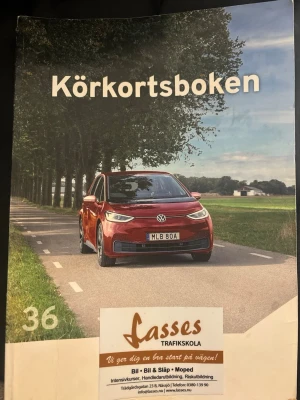 Körkortsboken - Körkortsboken upplaga 36 med omslag i färg, Boken används för teoristudier till bilkörkort och är tryckt på papper. Omslaget har reklam för Lasses Trafikskola. Perfekt för dig som pluggar till körkort. Pris kan diskuteras 