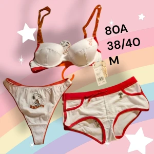 Snoopy underklädesset, BH, hipster och string - Sött underklädesset i tre delar med BH storlek 80A, hipster-trosor i storlek M och stringtrosor i storlek 38/40. BH:n har avtagbara lite genomskinliga orangea axelband och uttagbara inlägg. Helt oanvänd med orginallapparna kvar. Från konkurslager. Finns många fler varianter och storlekar. Rabatt vid flerköp.