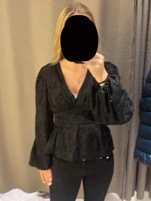 Svart spetsblus med v-ringning - Trendig svart blus i spets med v-ringning och markerad midja. Väldigt fin, mycket bra skick. Jag säljer den då den är lite stor på mig. Finnas inte att köpa längre. Ny pris || 499kr. 
