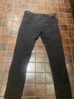 Svarta jeans från Replay - Säljer ett par svarta jeans från Replay med klassisk femficksmodell och raka ben. Jeansen har diskret logga på ena bakfickan och är tillverkade i ett mjukt bomullsmaterial med lite stretch för extra komfort. Perfekta för en stilren och enkel look. Storleken på jeansen är 31 32. Finns tecken på användning så därför är priset så lågt! Hör av er för med bilder eller tankar!