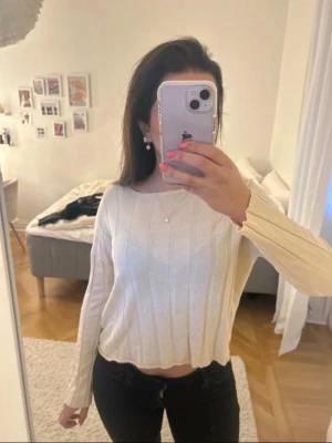 Beige ribbstickad cropped tröja - Säljer en beige stickad tröja med ribbade vertikala ränder och lång ärm. Tröjan är cropped och har en enkel rund halsringning. Materialet känns mjukt och lätt.