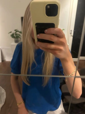 Blå basic t-shirt - En enkel blå t-shirt med rund hals och korta ärmar. Perfekt för en avslappnad stil och lätt att matcha med andra plagg. T-shirten har en klassisk passform och är tillverkad i ett mjukt material.