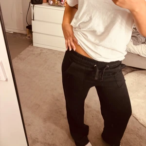 Svarta mjukisbyxor med snörning - Svarta mjukisbyxor från lager 157 med elastisk midja och snörning framtill. Byxorna har två fickor fram och två bak, raka ben och är gjorda i mjukt bomullsmaterial. Perfekta för chill dagar eller när du vill vara extra bekväm.