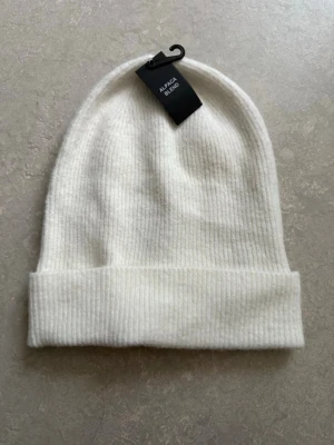 Vit ribbad mössa från Bik Bok i Alpaca Blend - Säljer en stilren vit mössa från Bik Bok i ribbstickad design.🤍