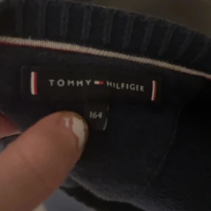 Mörkblå tröja från Tommy Hilfiger - En stickad tröja från Tommy Hilfiger i storlek 164 men passar mig som bär xs-s i storlek.🤩 Jätte fin kvalite och verkar inte säljas någonstans längre🥰🥰