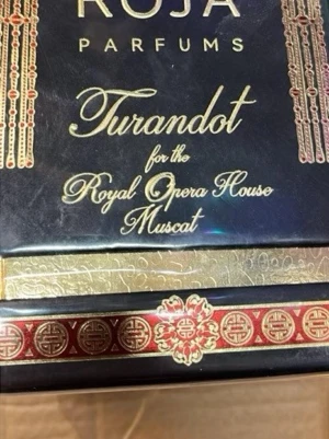 Roja Parfums Turandot Muscat - Lyxig parfym från Roja Parfums, Turandot för Royal Opera House Muscat. Förpackningen är svart med gulddetaljer och röda orientaliska mönster, vilket ger en exklusiv och elegant känsla. Perfekt för dig som gillar unika och sofistikerade dofter.