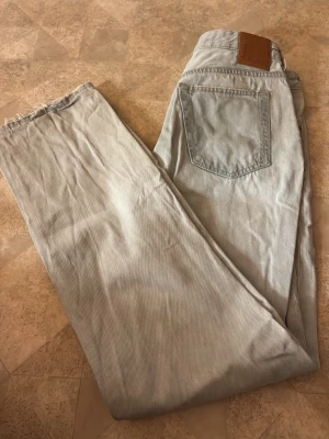 Ljusblå raka jeans från Lee - Säljer ett par ljusblå jeans från Lee med rak passform och klassisk femficksdesign. Jeansen har en läderpatch med Lee-logga bak i midjan och är tillverkade i bomull. Perfekta för en avslappnad och trendig look.