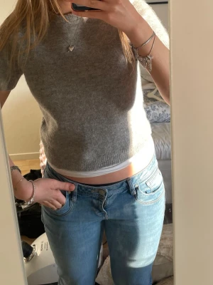 Grå croppad stickad topp från Zara - Grå croppad stickad topp från Zara med korta ärmar och rund hals. Enkel och stilren design som passar perfekt till jeans eller kjol. Mjuk och skön kvalitet som känns lyxig mot huden. I st M och är i väldigt fint skick💕☺️