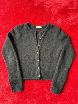 Svart stickad - Svart stickad tröja med knappar från Gina Tricot, storlek S. Använd några gånger, men i mycket gott skick. Klassisk och stilren design som passar både vardag och lite finare tillfällen. Snabb leverans möjlig – passa på att fynda en nästan ny tröja!