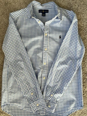 Ralph Lauren Skjorta - Blå och vit rutig skjorta från Ralph Lauren. Mycket bra skick. OG storlek är L men den är liten i storlek, sitter som M.