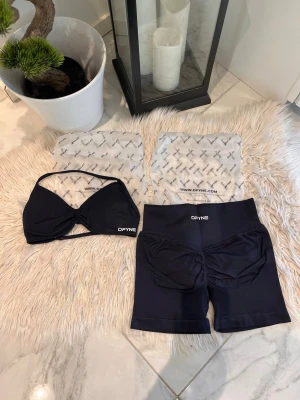 Midnight black sportigt set från DFYNE - Säljer ett svart sportigt underklädesset från DFYNE med vadderad topp och matchande shorts. Setet har en stilren design med diskreta loggor och elastiskt material som ger bra passform. Perfekt för dig som gillar bekväma och snygga underkläder. Impact 4.5 , Midnight black 